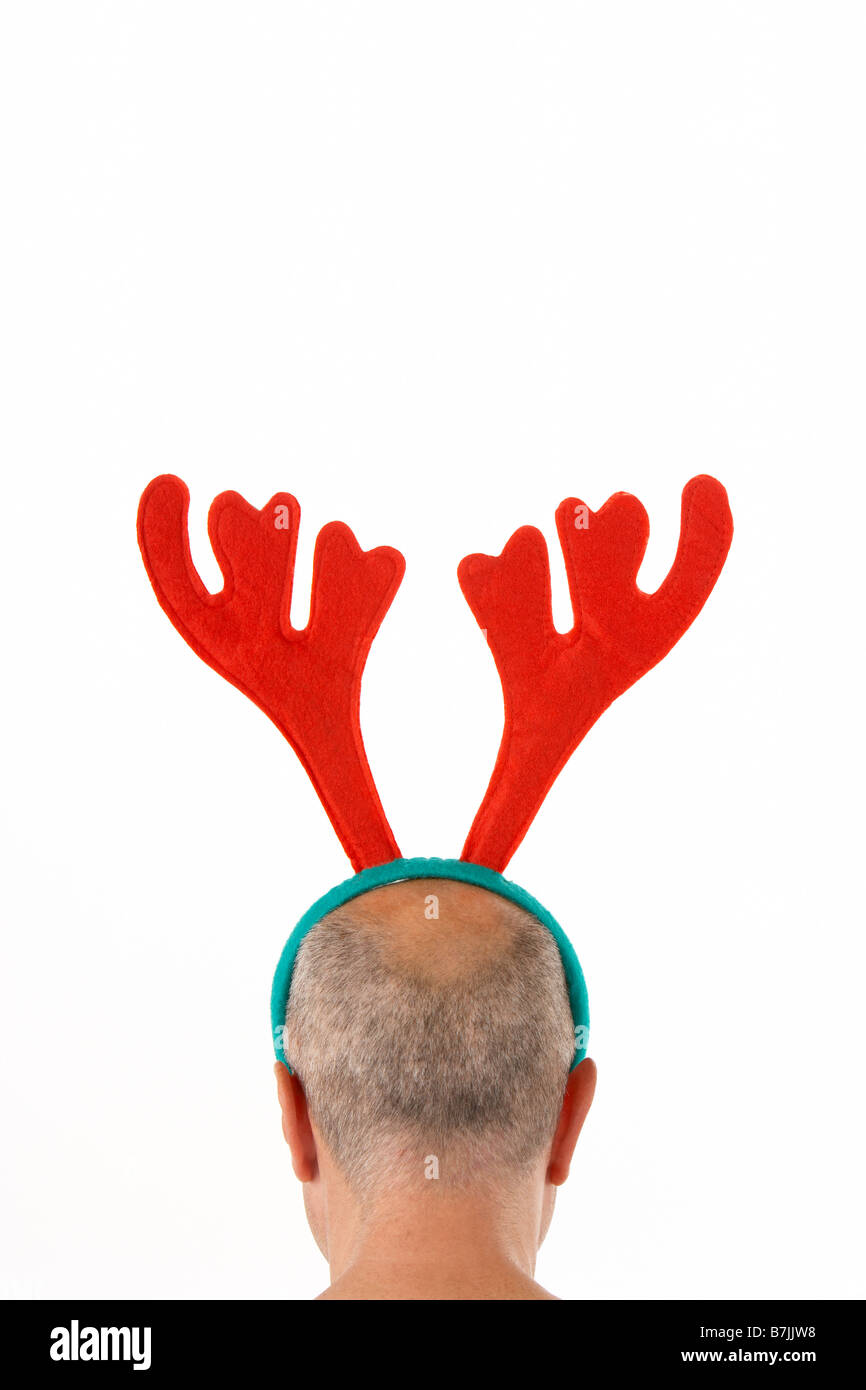 Man Wearing Reindeer Antlers Against White Background Stock Photo