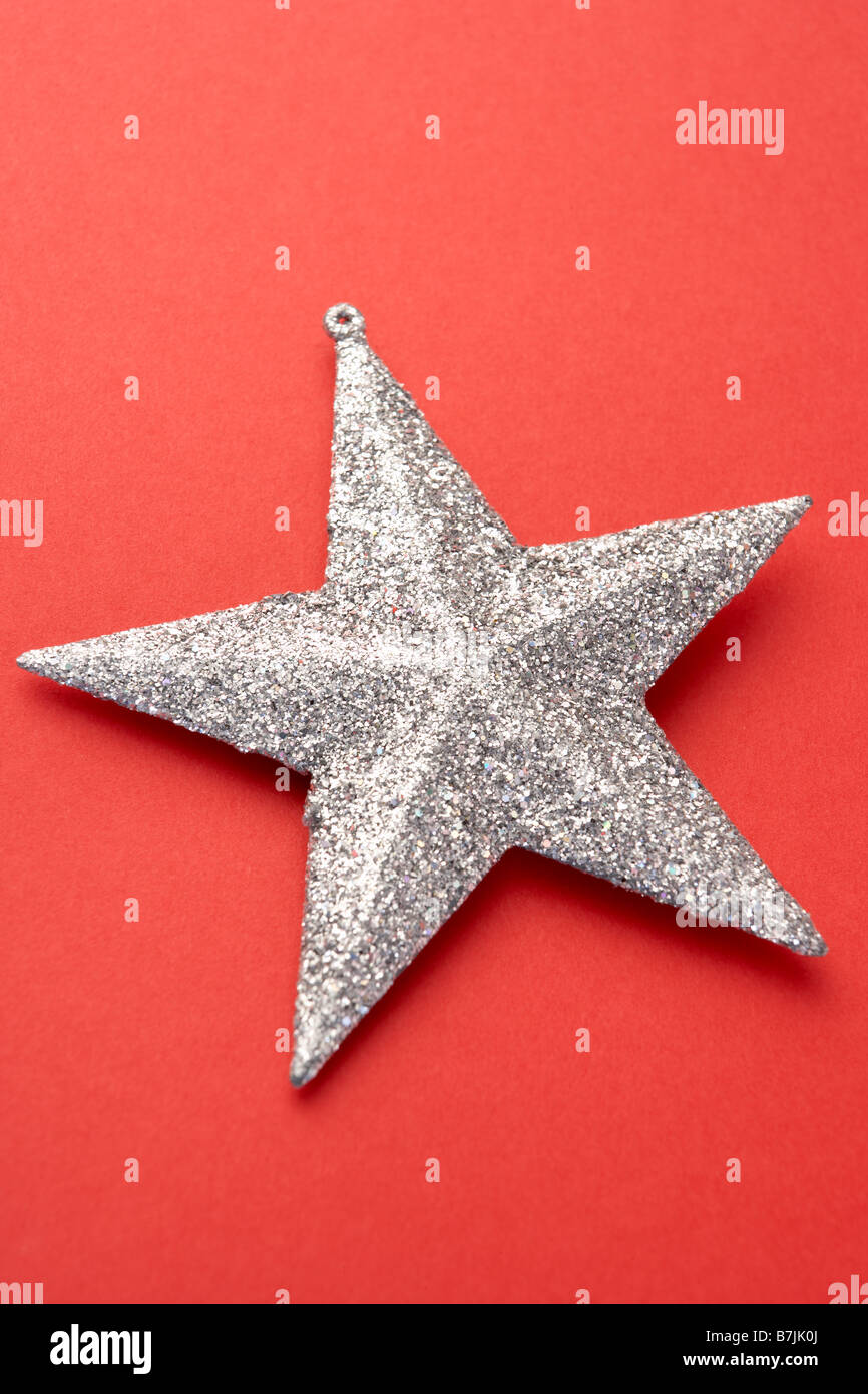 Silver Star Christmas Tree Decoration On Red Background Stock Photo