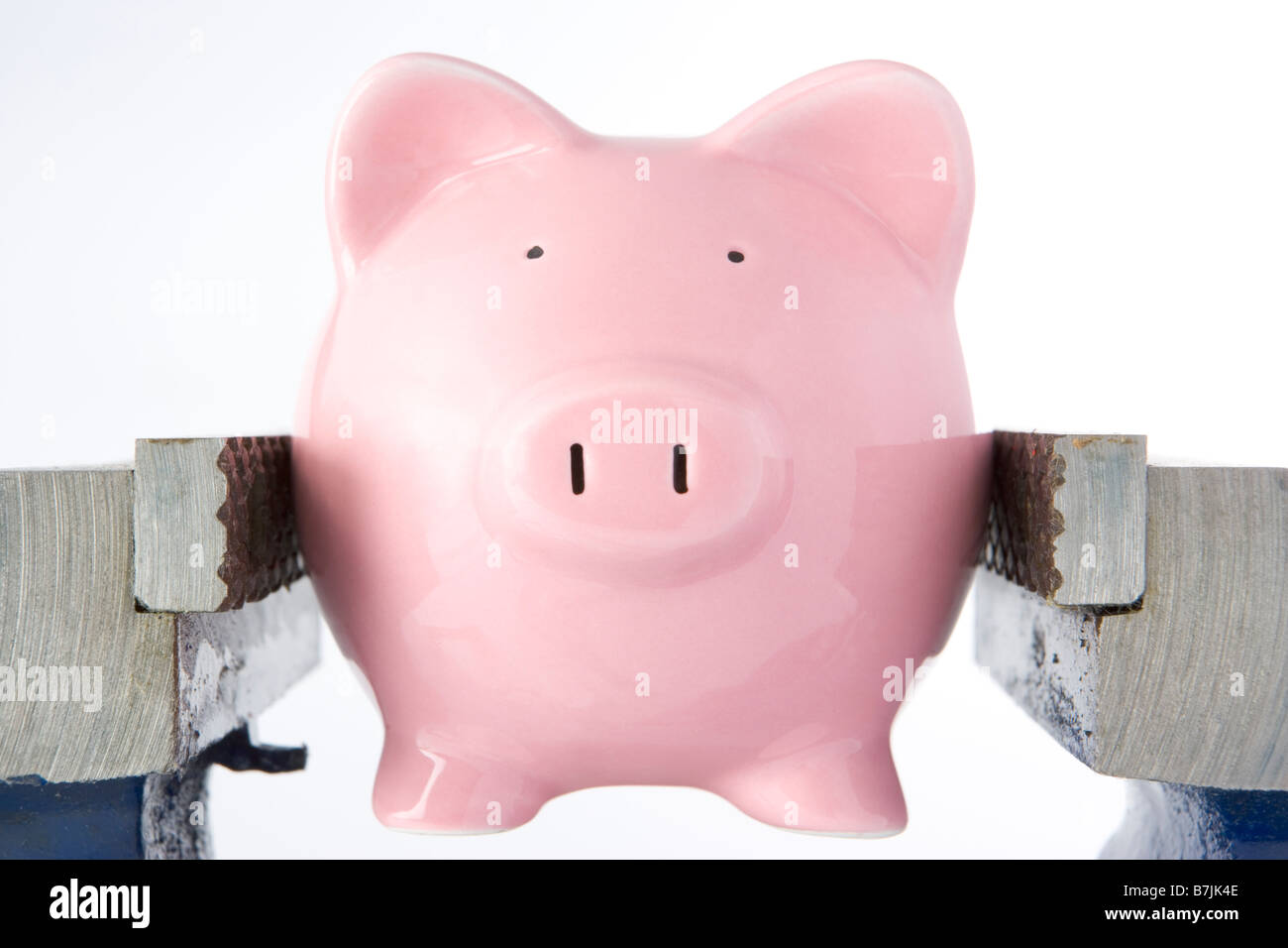 Piggy Bank In Jaws Of Vice Against White Background Stock Photo