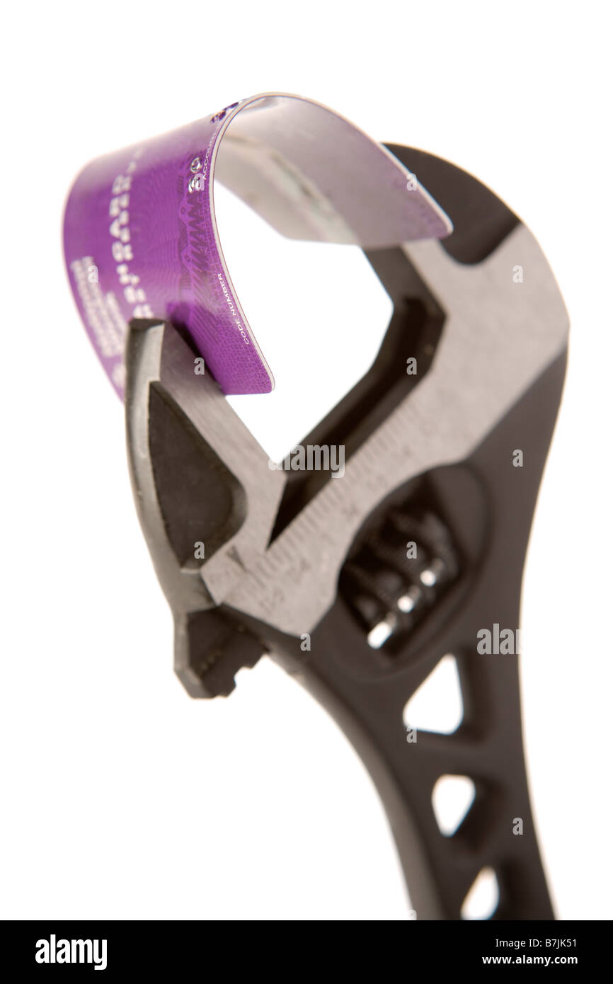 Credit Card Held In Wrench Against White Background Stock Photo