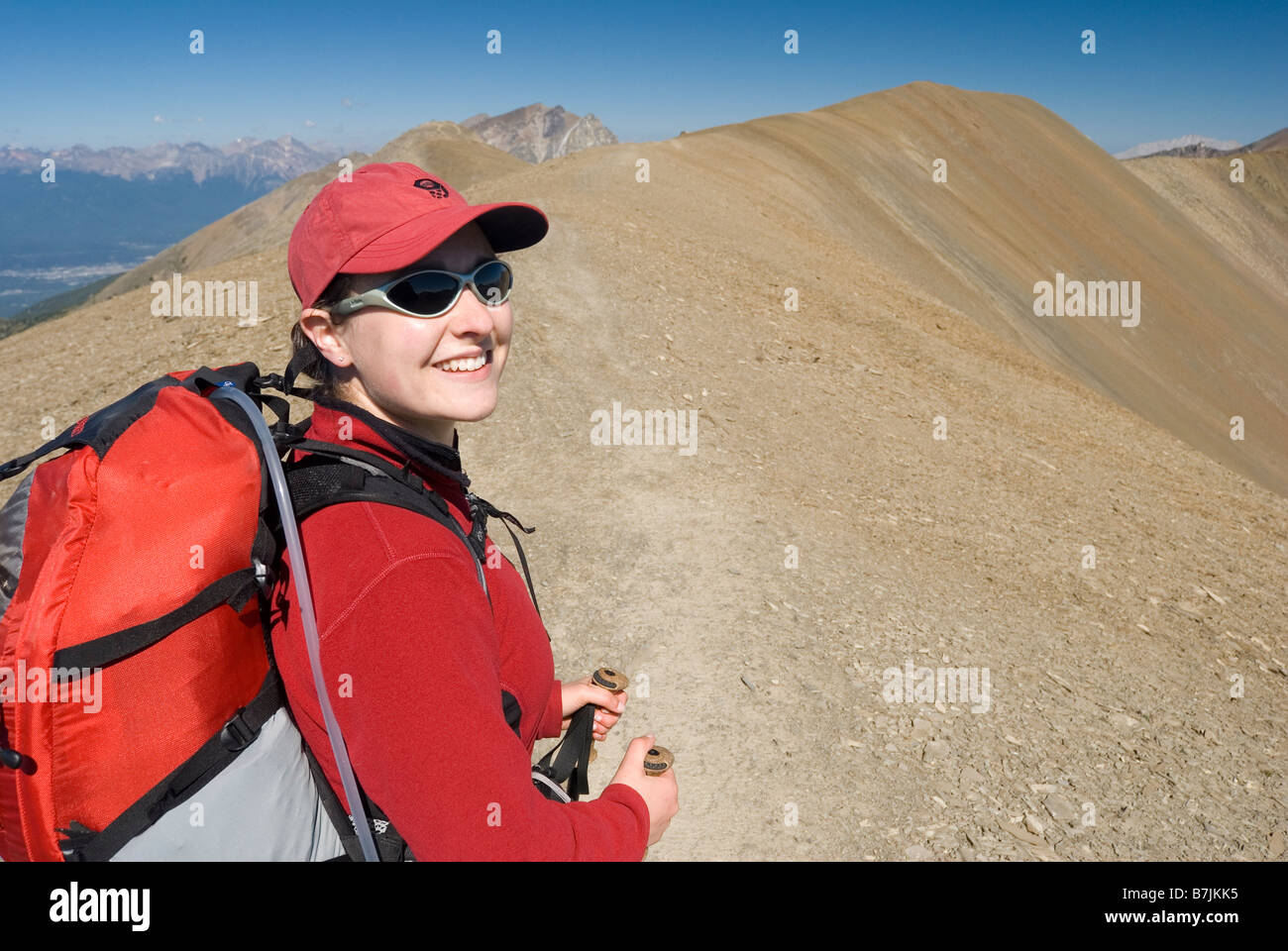 A woman (2025) smiles while hiking in the alpine; Canada, Alberta, Jasper National Park