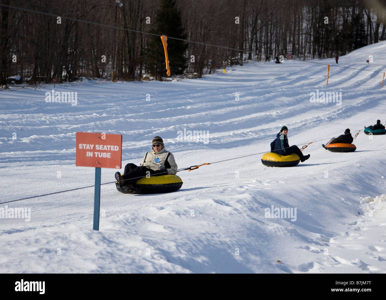 Tubes and riders being pulled up a hill Stock Photo