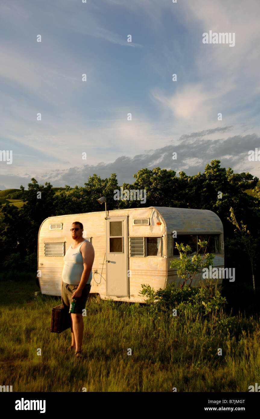 Man with briefcase stands in front of dumpy trailor; Canada, Saskatchewan, Regina Stock Photo