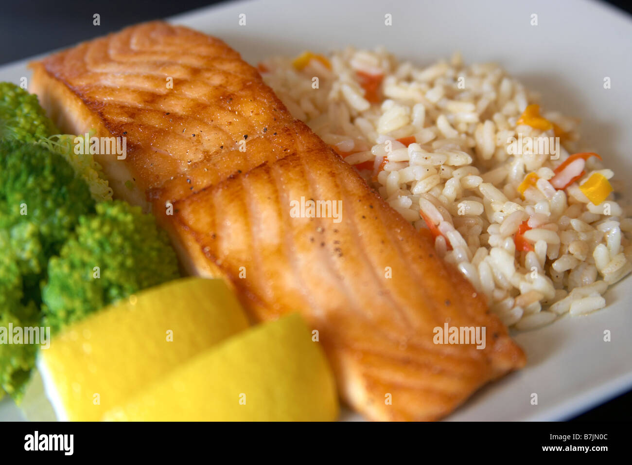 Dinner plate of salmon with rice and broccoli garnished with lemon wedges, Canada, Ontario Stock Photo