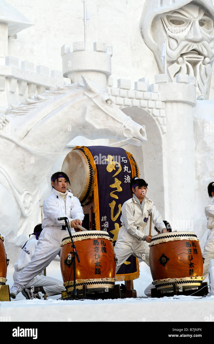 Japanese girls playing traditional taiko drums on the giant snow sculpture at the Sapporo Yuki Festival. Stock Photo