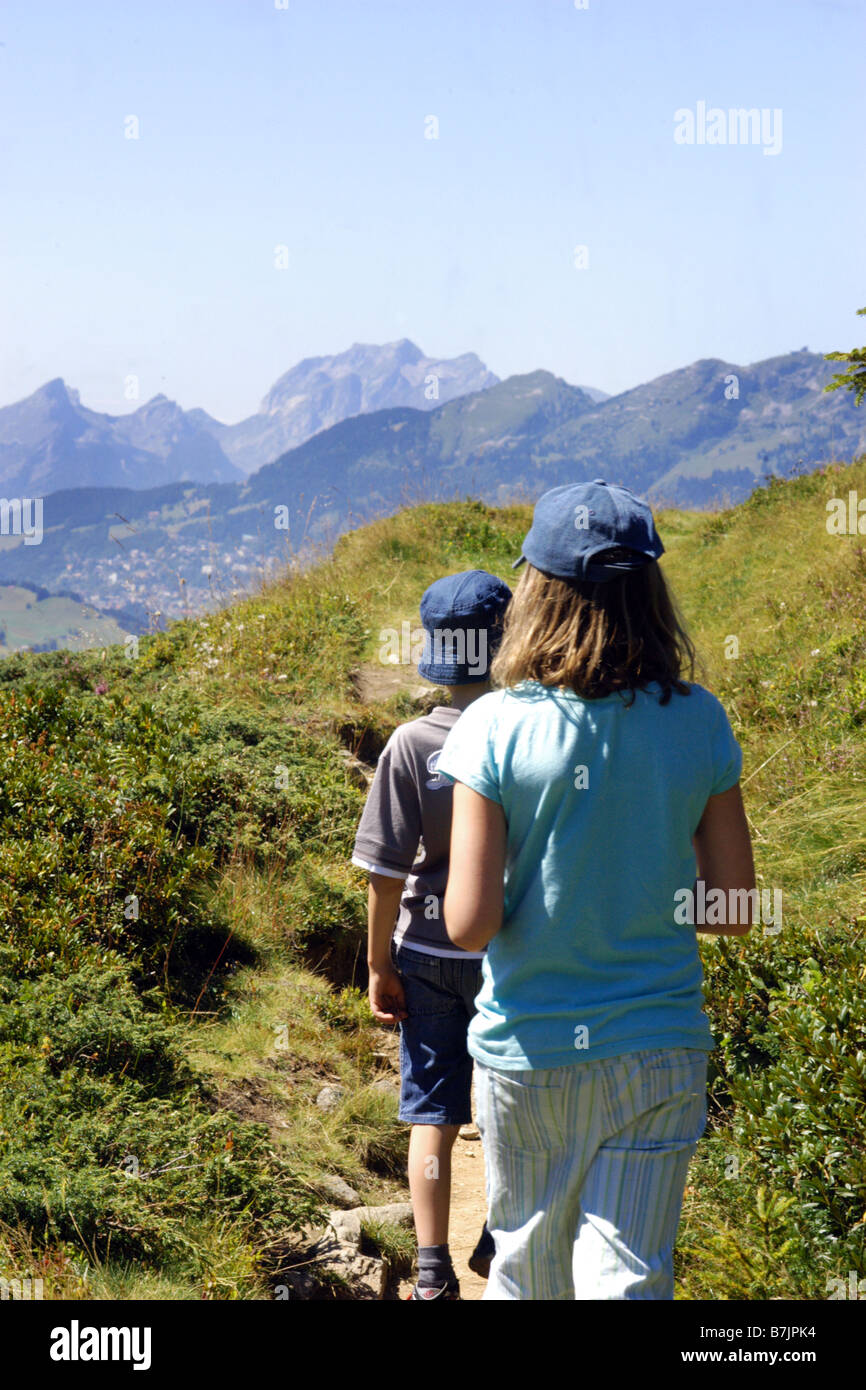 Two children walk in the Swiss Alps while on holiday Stock Photo