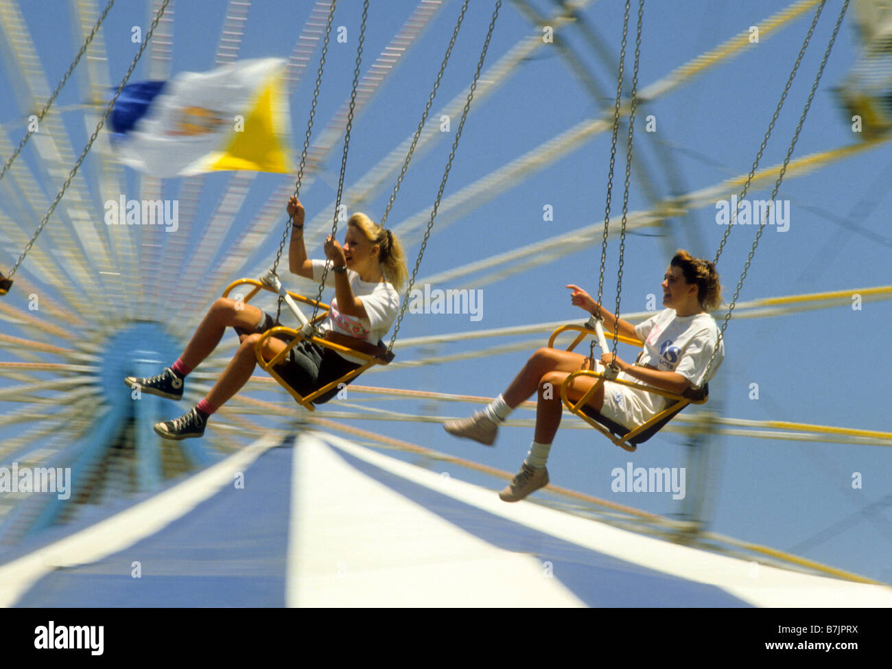 Teen boy and girl ride in carnival swings at county fair Stock Photo ...