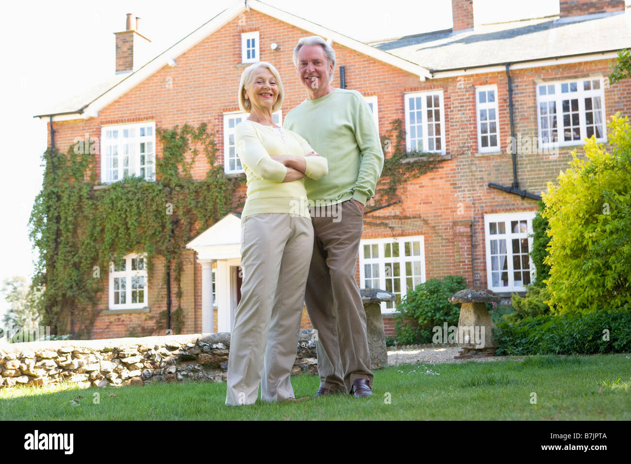 Couple Standing Outside Their House Stock Photo - Alamy