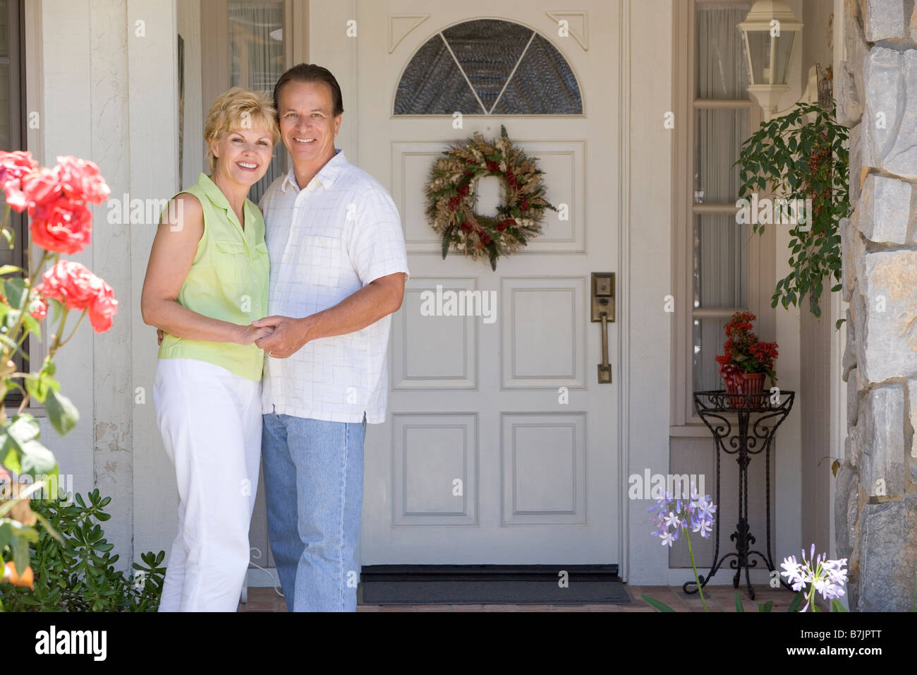 Couple Standing Outside Their House Stock Photo - Alamy