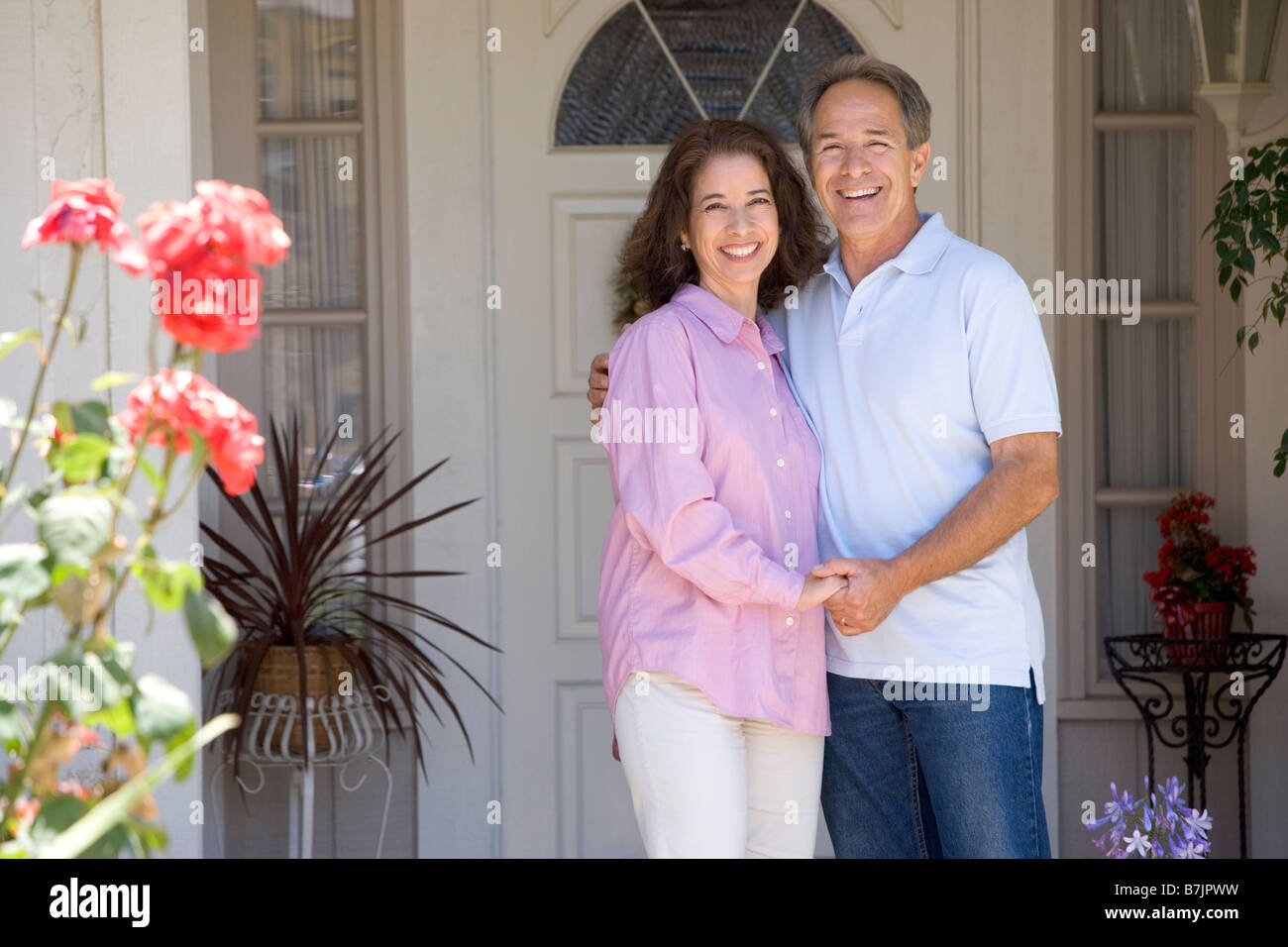 Couple Standing Outside Their House Stock Photo - Alamy