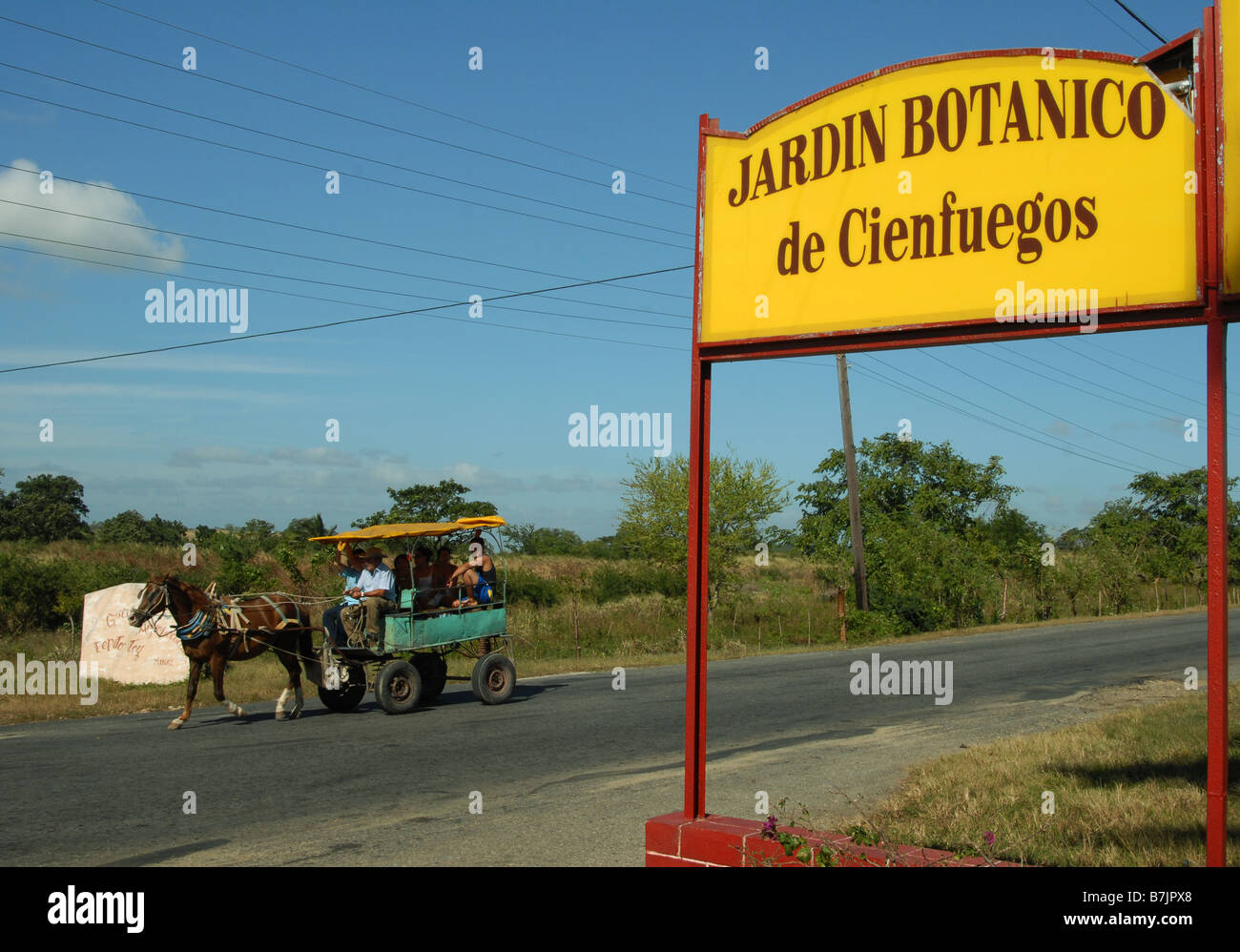 Horse-drawn taxi passing the entrance to the Cienfuegos Botanical Gardens in Cuba Stock Photo