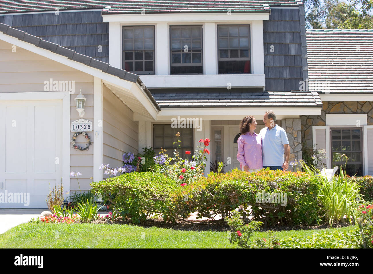Couple Standing Outside Their House Stock Photo - Alamy