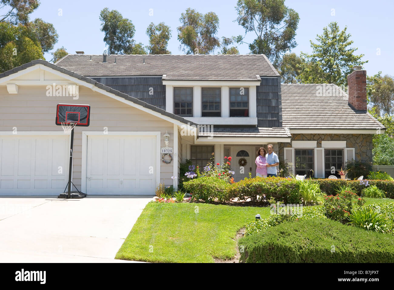 Couple Standing Outside Their House Stock Photo - Alamy