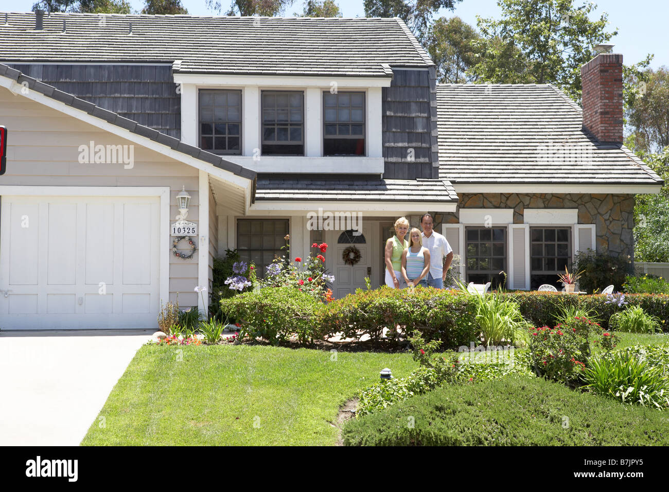 Family Standing Outside House Stock Photo Alamy