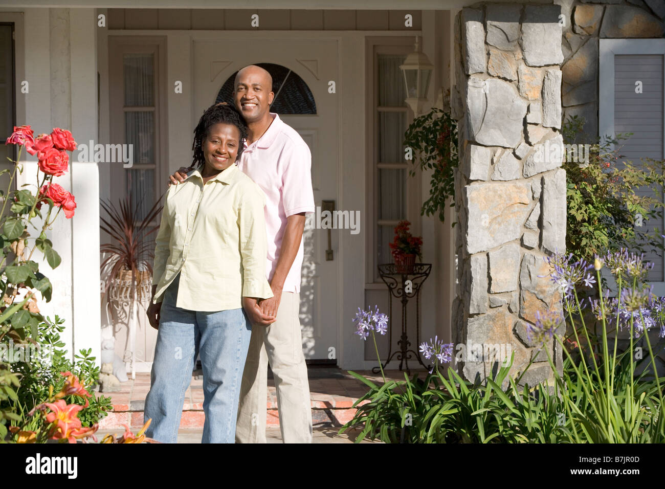Couple Standing Outside Their House Stock Photo - Alamy