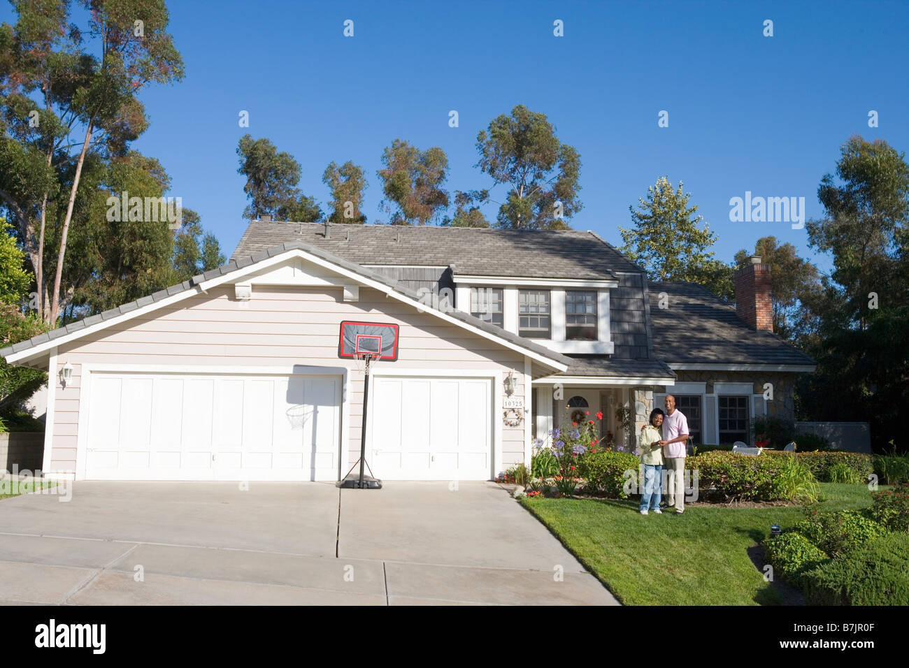 Couple Standing Outside Their House Stock Photo - Alamy