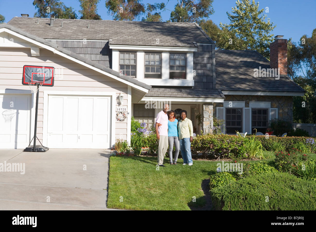 Family Standing Outside House Stock Photo Alamy