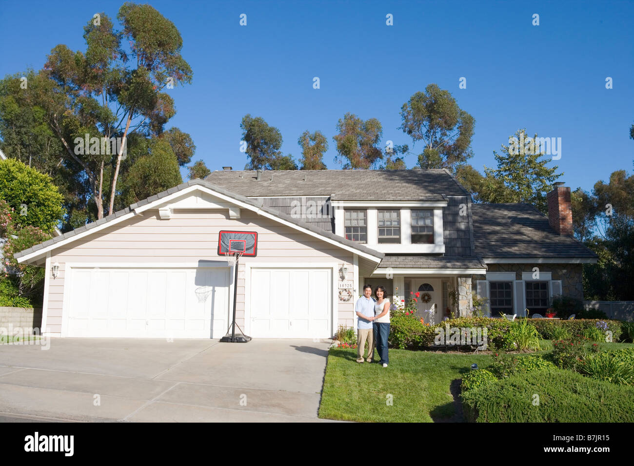 Couple Standing Outside Their House Stock Photo - Alamy