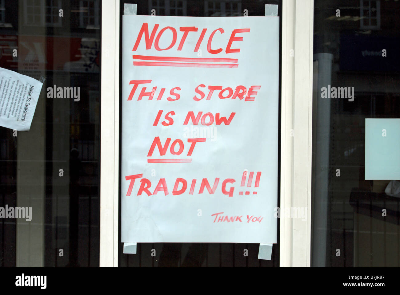 handwritten notice in shop window stating 'this store is now not trading', at former woolworths, twickenham, middlesex, england Stock Photo