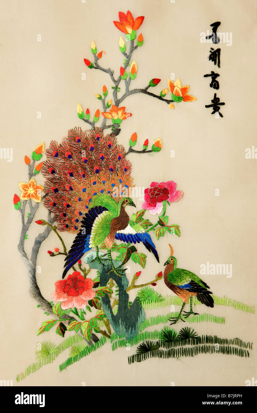 Colourful chinese silk embroidery of peacocks and bush in flower with text meaning 'Love to see wealth' JMH3778 Stock Photo