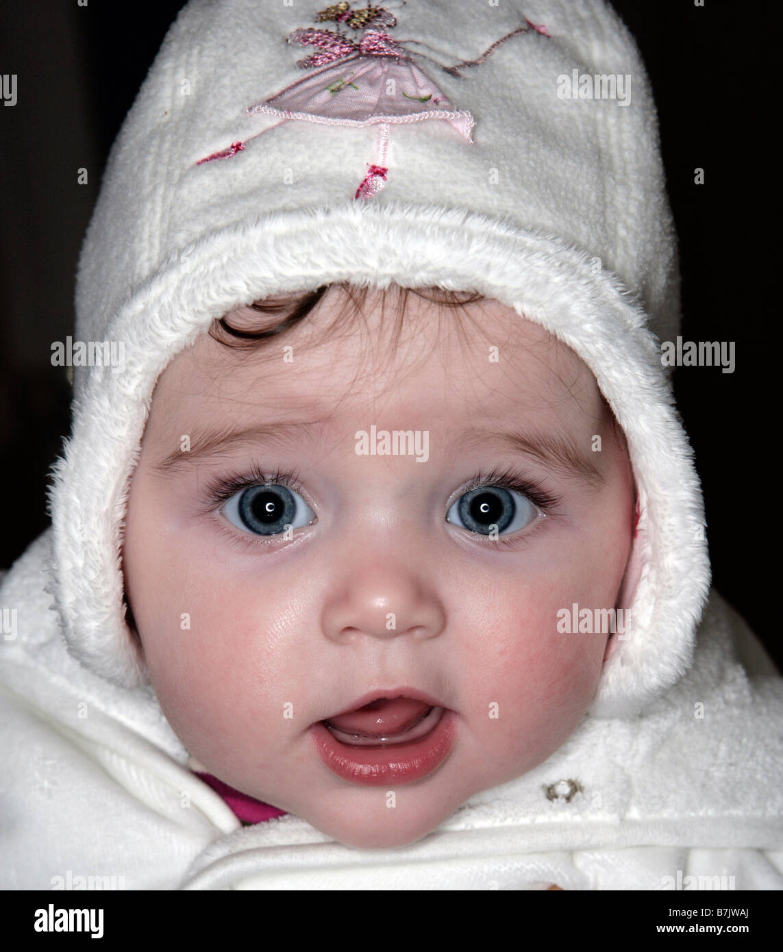 A  baby girl wrapped up warm in hat and coat Stock Photo