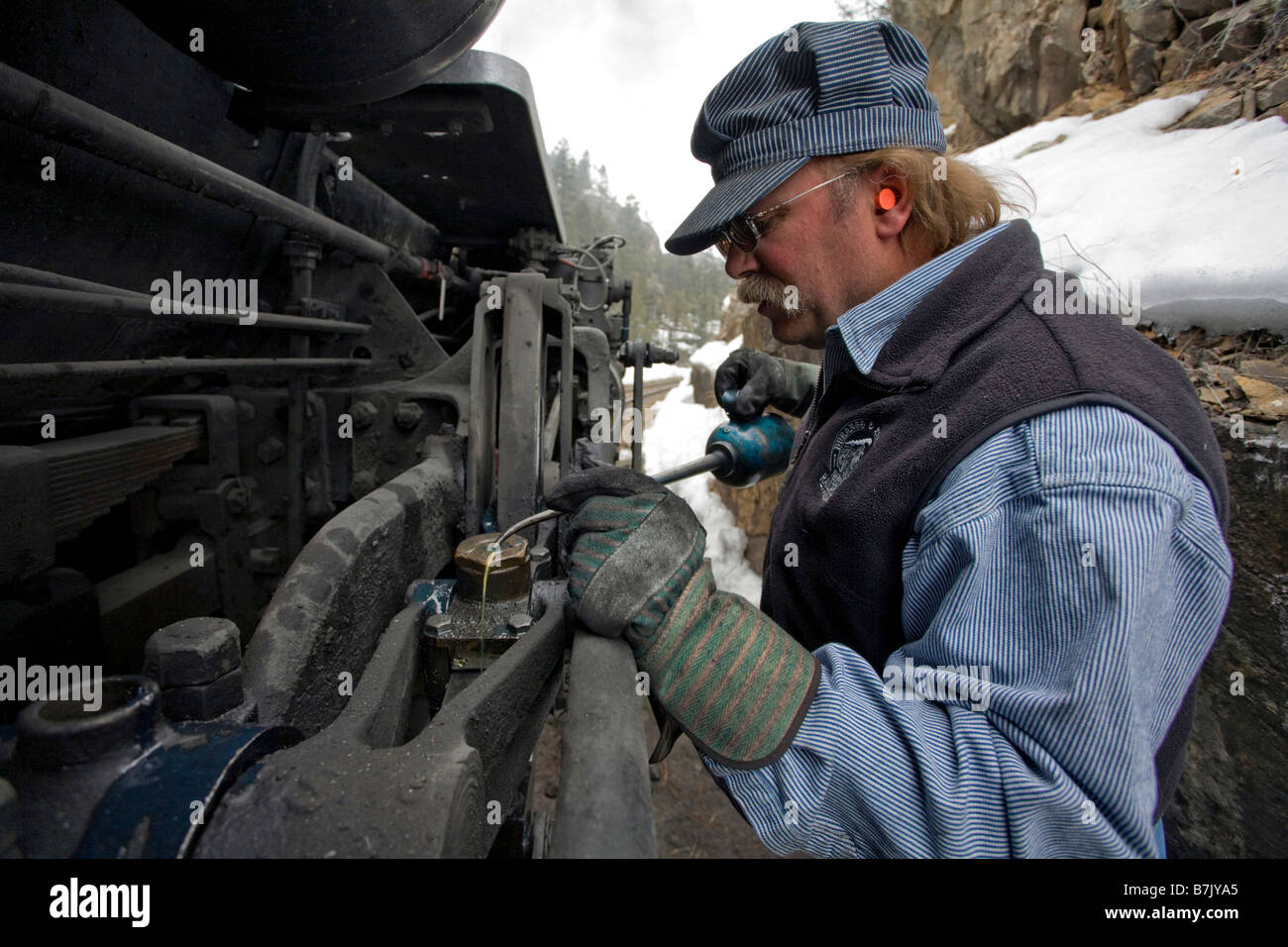 Engineer maintains a steam powered locomotive on the Durango Silverton Narrow Gauge Railroad in southwestern Colorado Stock Photo