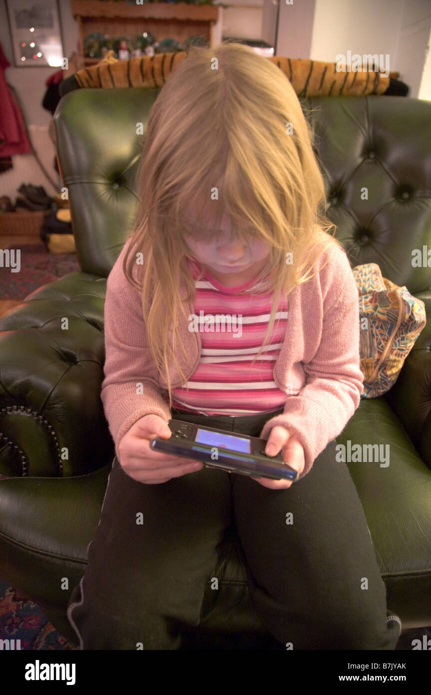 5 year old girl playing Nintendo ds Lite console Stock Photo