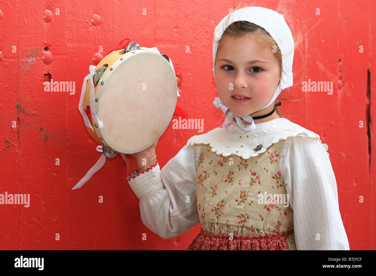 Young girl in traditional dress holding a tambourine in SaintesMaries