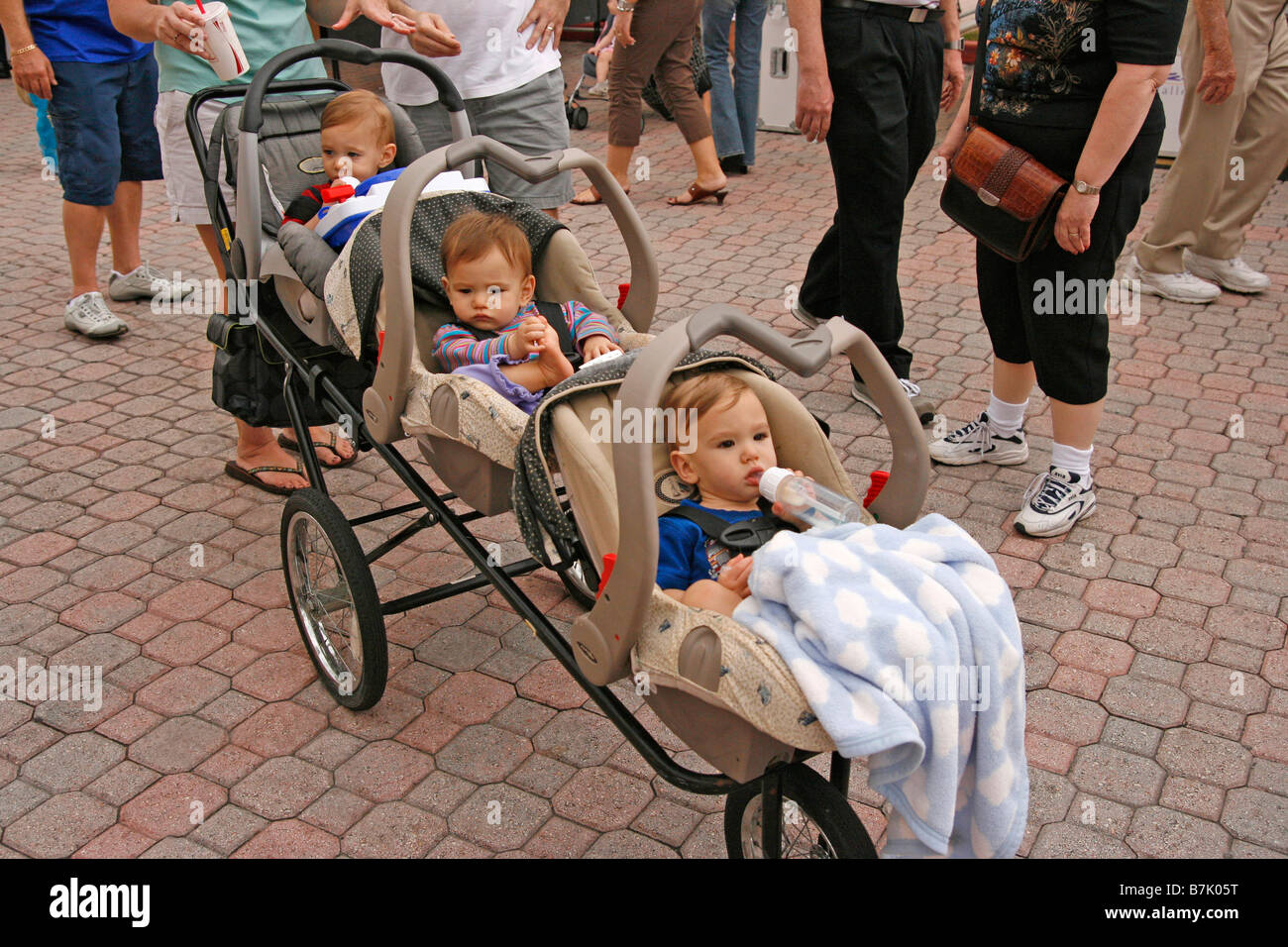 Triplets 6 months old outdoors in a stroller Stock Photo