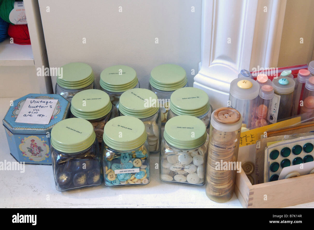 Jars and packets full of different buttons for sale some vintage some chunky some casein. Stock Photo