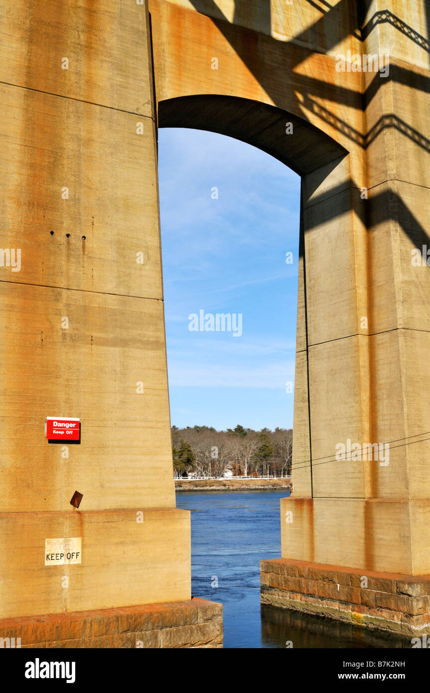 Abstract view of a concrete bridge support pylon with archway and view to water Stock Photo