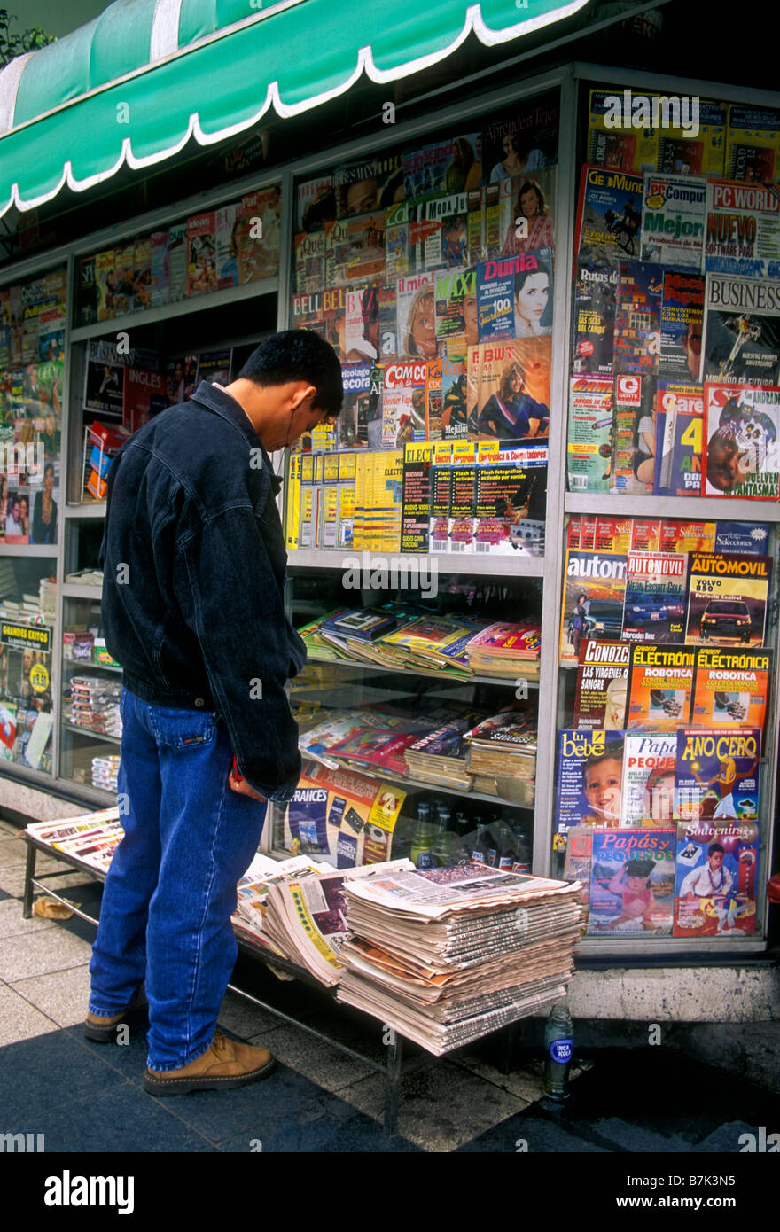 Peruvian man, young man reading newspaper, newsstand, newspaper stand, kiosk, Miraflores district, Lima, Lima Province, Peru, South America Stock Photo