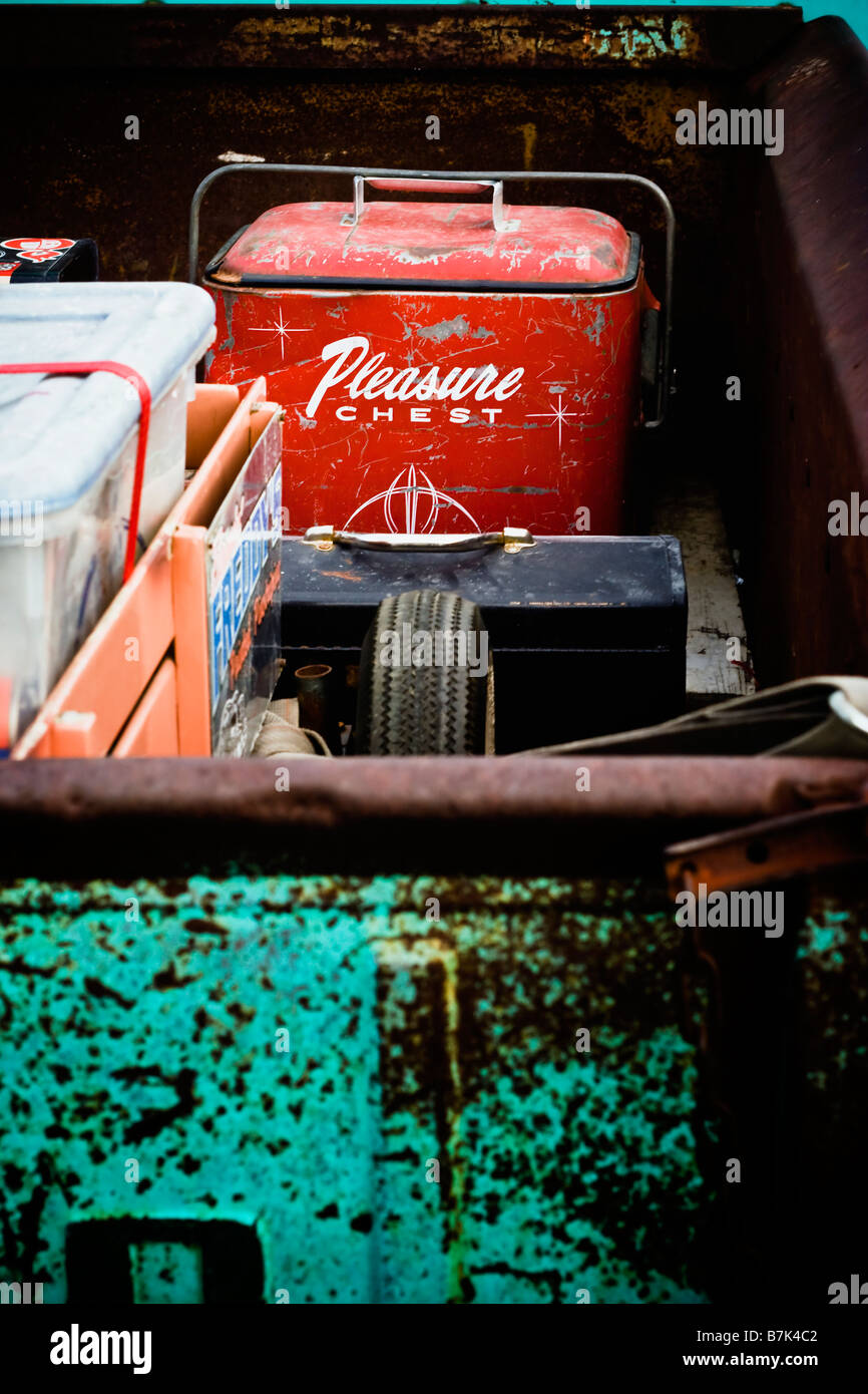 The bed of an old rusty Ford pickup truck with a toolbox and cooler. Stock Photo