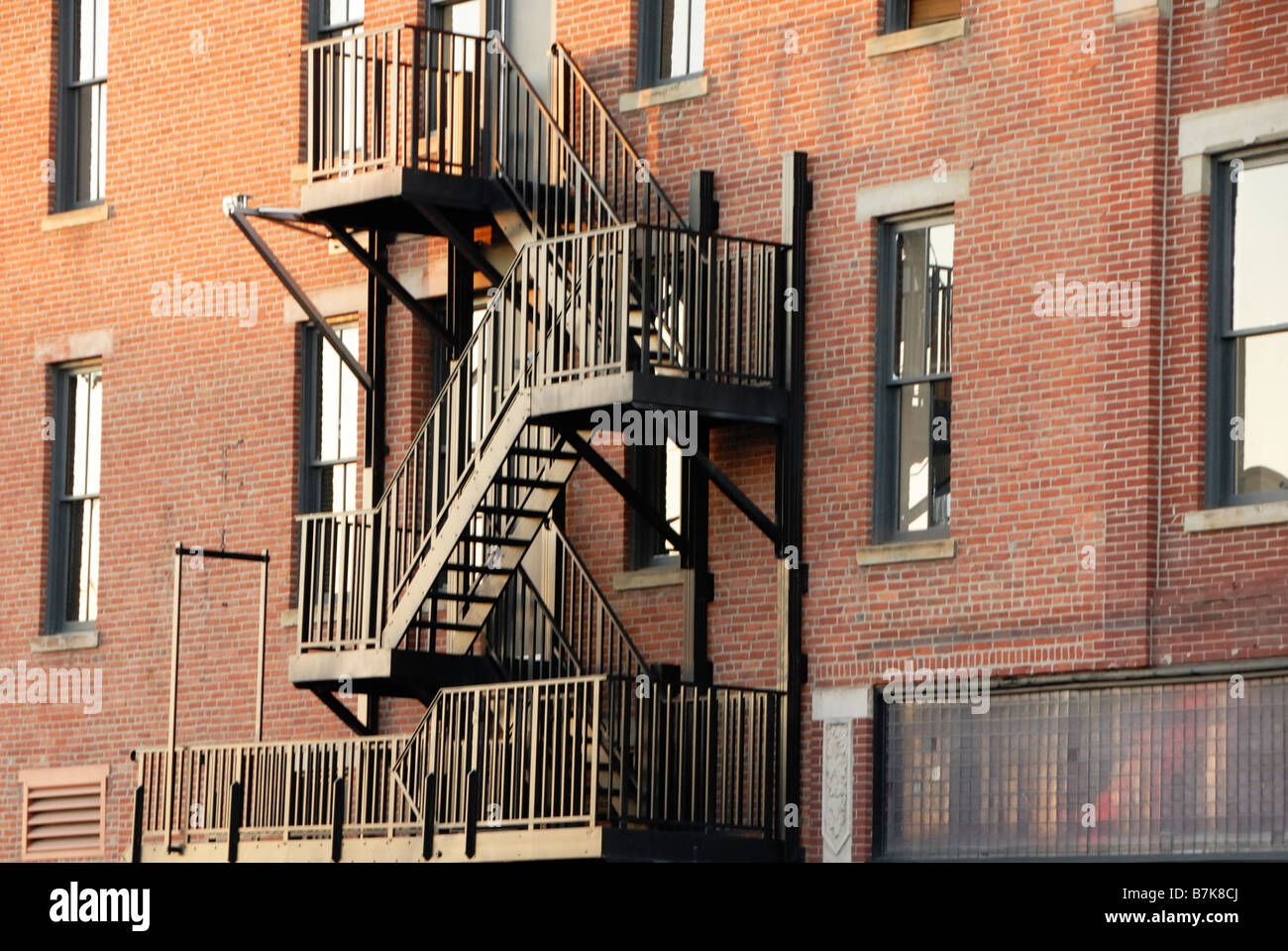 Fire escape on side of red brick building Stock Photo