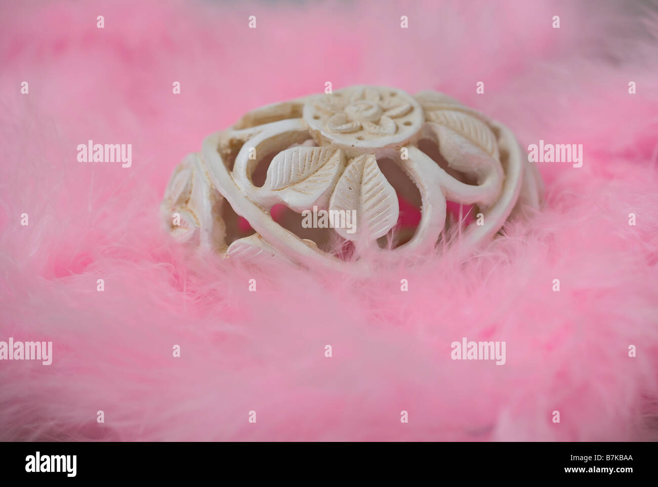 Decorative carved Easter egg resting on pink feathers Stock Photo