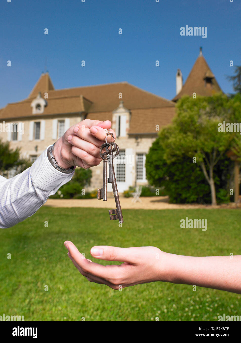 Woman receiving keys to country home Stock Photo