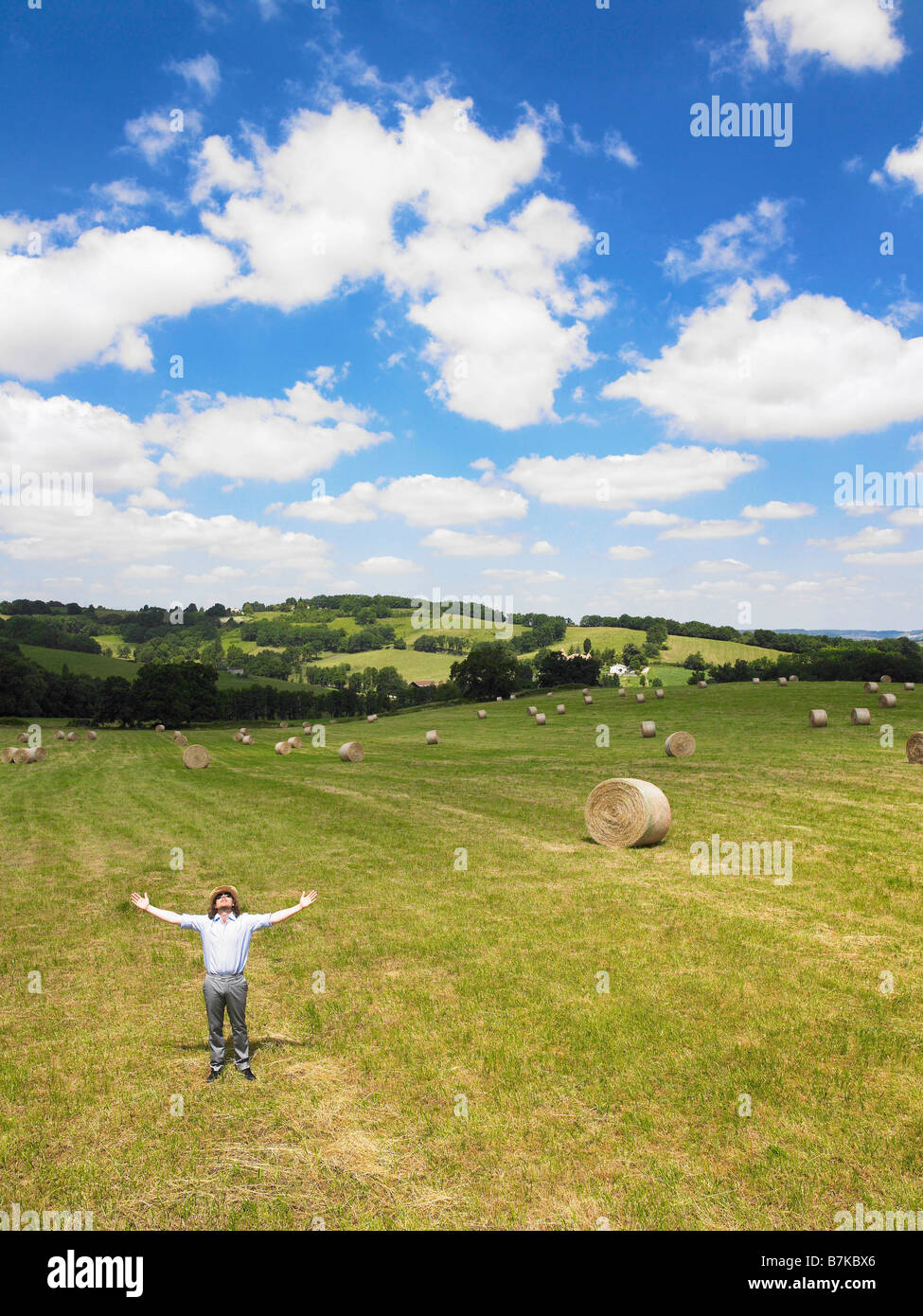 Man in field with arms open Stock Photo