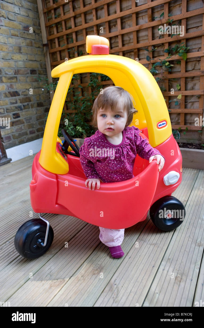 a-baby-girl-plays-with-a-toy-car-in-the-garden-B7KCRJ.jpg