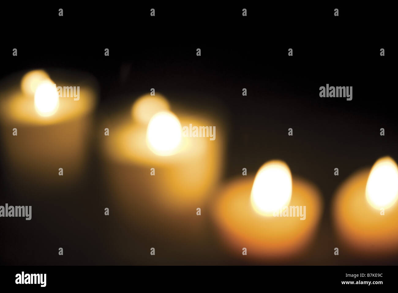 Romantic lighting: row of candles against a black background Stock ...