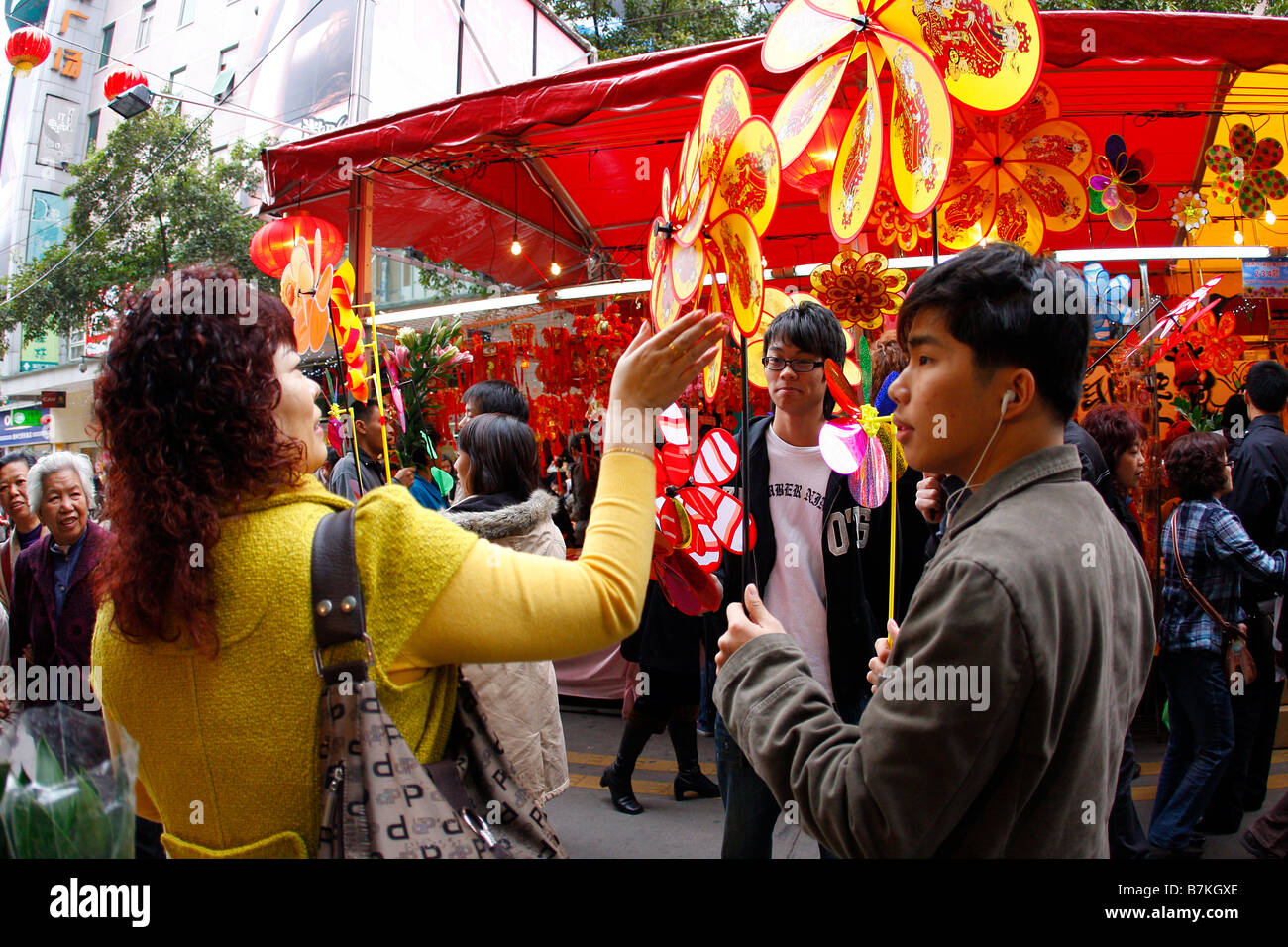 Chinese Students selling traditional lucky pinwheels at Flower market durring Chinese New Year Stock Photo