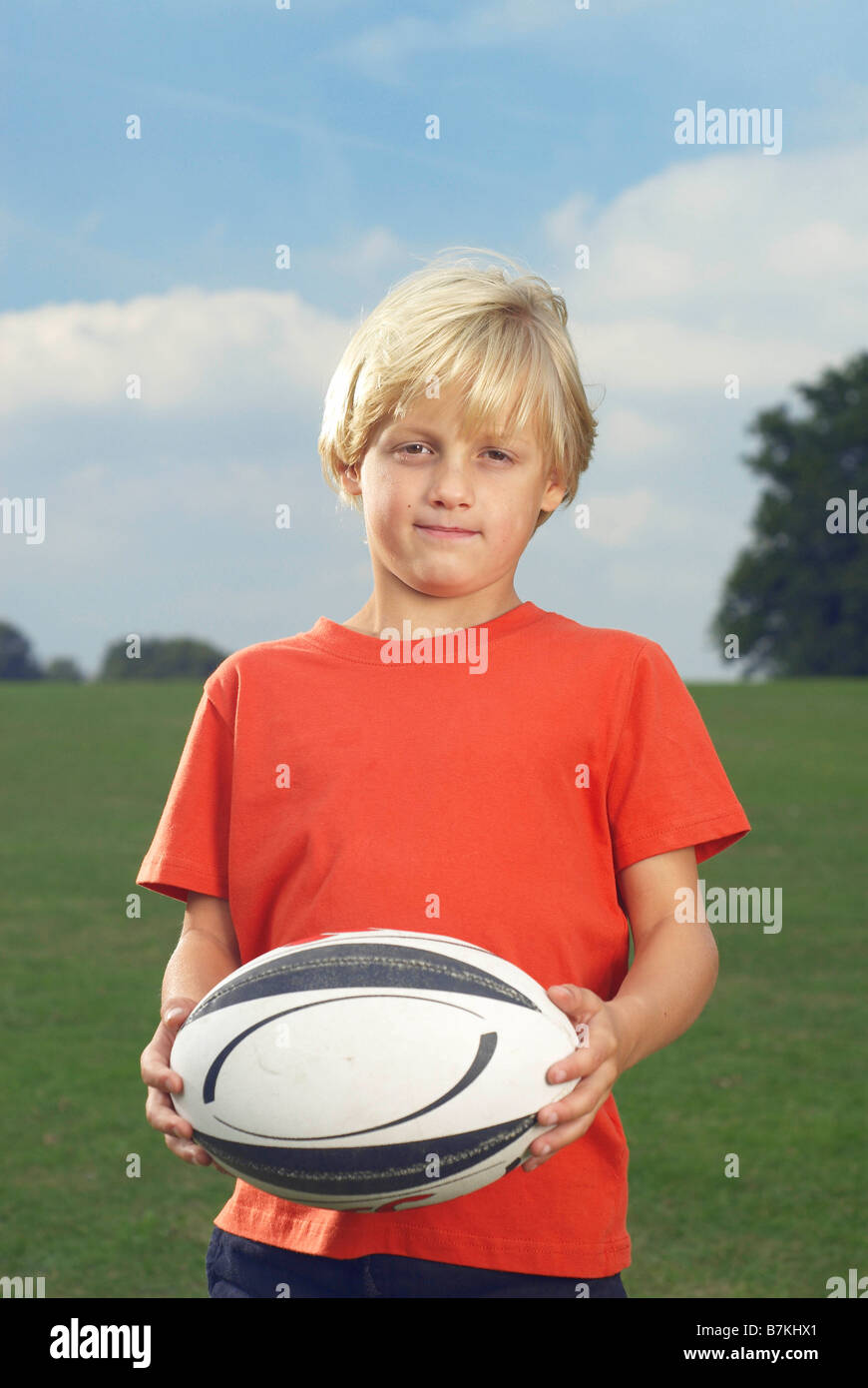 boy holding rugby ball in filed Stock Photo Alamy