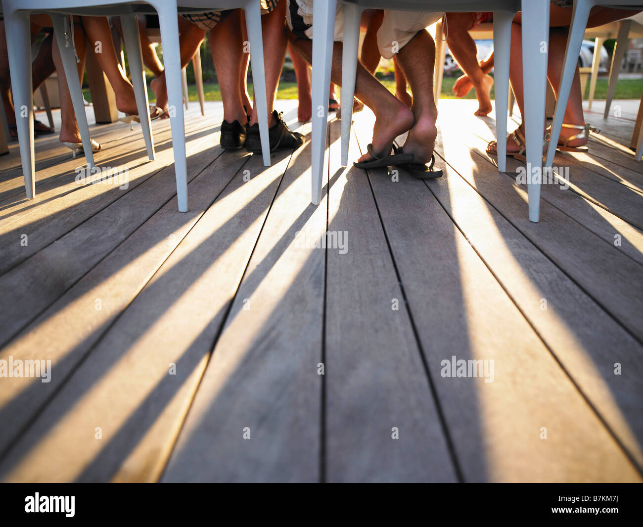 Many legs under table casting shadows Stock Photo
