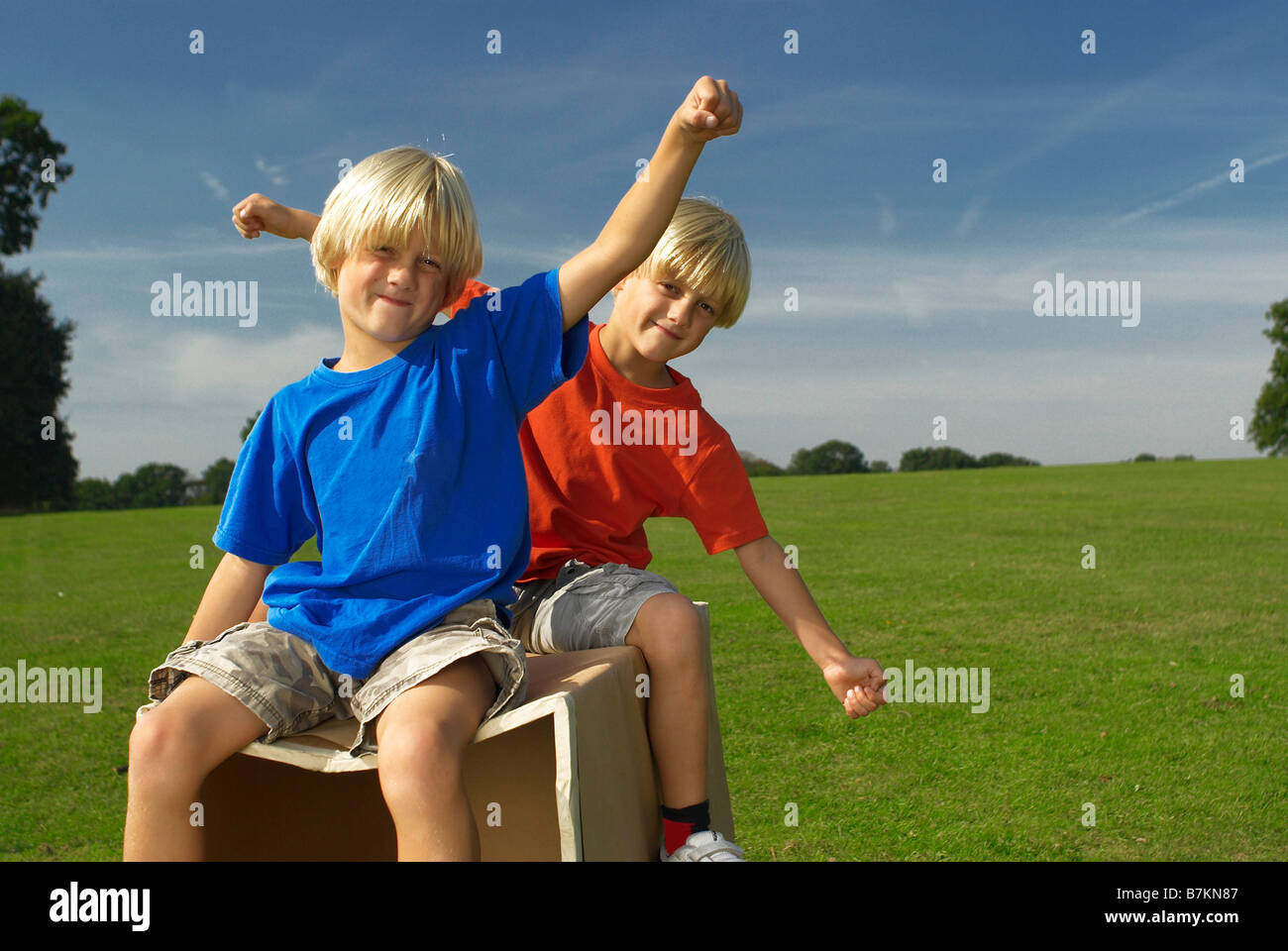 boys on a box, arms out Stock Photo