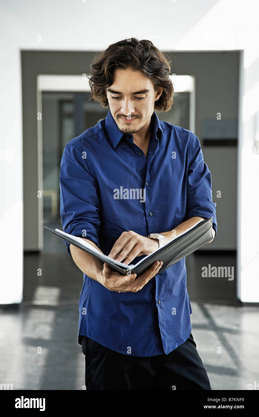 Man looking at a file Stock Photo - Alamy