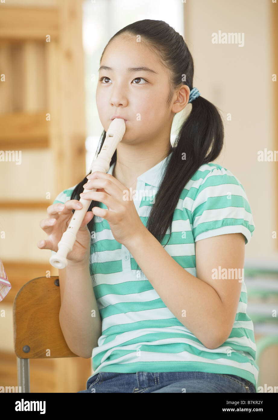 Elementary school girl playing recorder Stock Photo Alamy