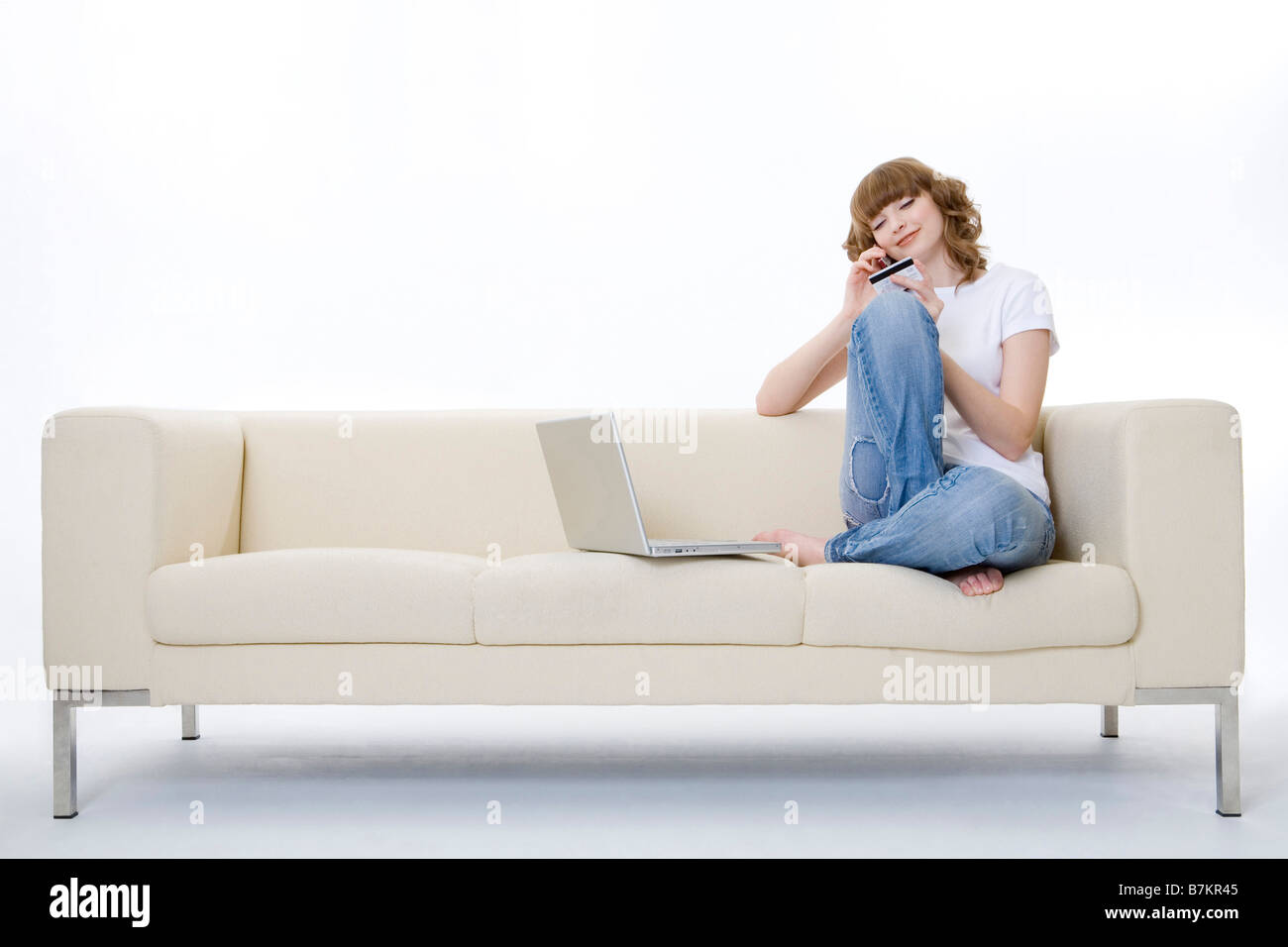 Teenage girl on the phone sitting on sofa Stock Photo - Alamy