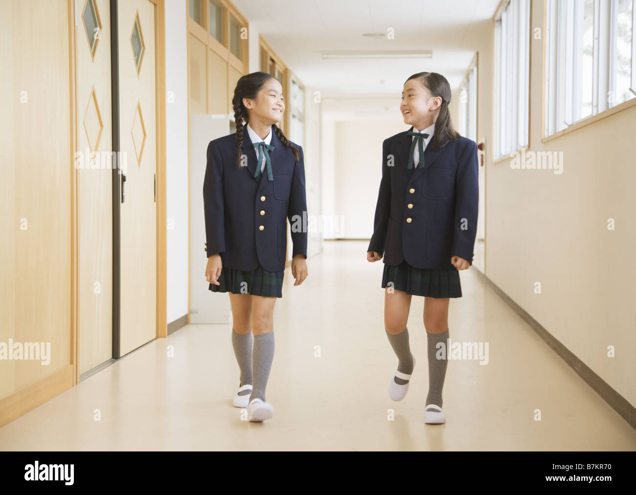 Elementary students walking along the corridor Stock Photo - Alamy