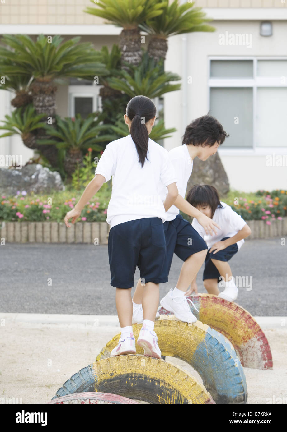 Elementary students playing with play equipment Stock Photo Alamy