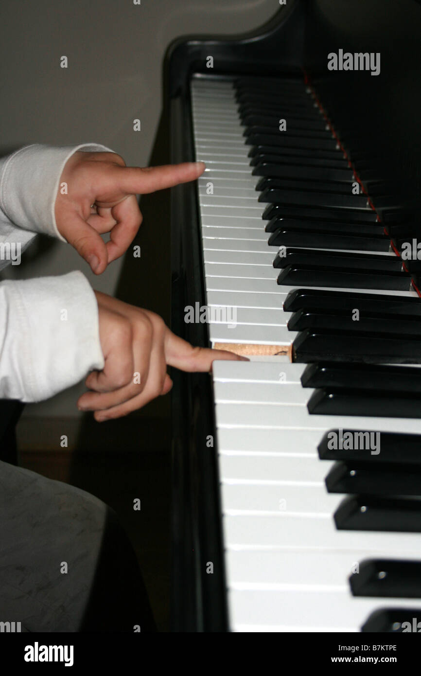 closeup of six year old boy playing the piano for the first time