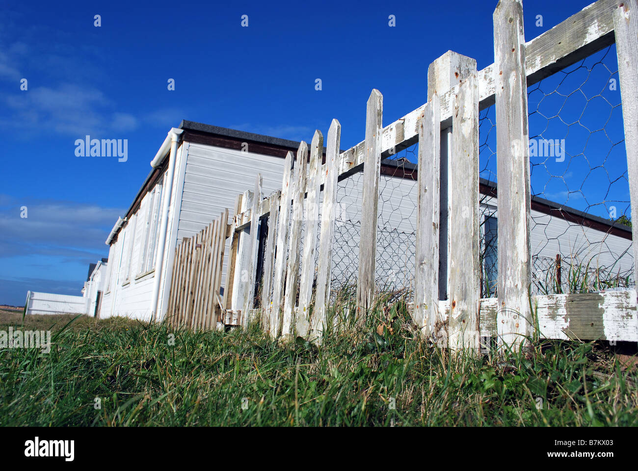 White picket fence around a beach house Stock Photo